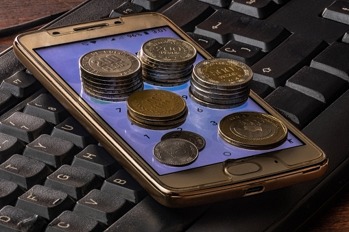 Coins on the keyboard of a smartphone. Business concept.Colombian money