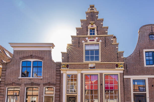 Traditional dutch buildings stand tall in deventer, netherlands, showcasing unique architectural details under a clear blue sky