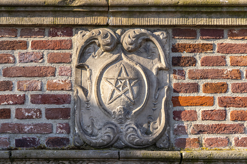 Europe, Netherlands, North Holland, Enkhuizen. Decorative relief with a star on a brick building.