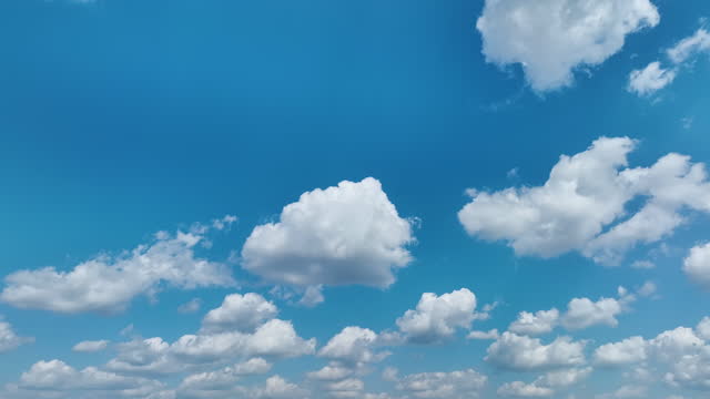 White puffy cumulus clouds on summer blue sky