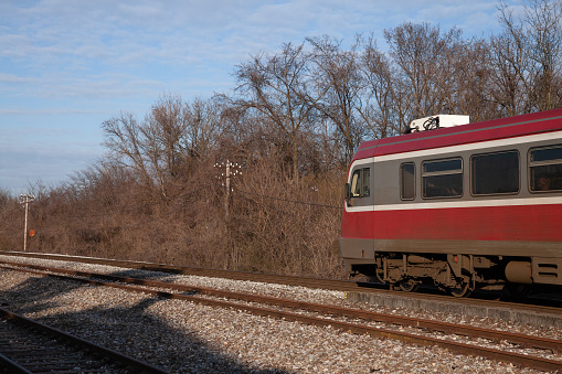 Fairfax Station, Virginia, USA - March 14, 2024: A Virginia Railway Express (VRE) commuter train travels on a curve heading Westbound on a sunny afternoon.