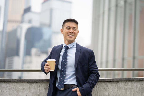 istock Successful executive leaning against railings holding a cup of coffee 1485865775