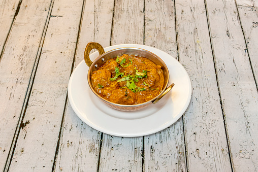 Mild dry curry with lamb stew juice in pure Hindu bhuma style in traditional metal bowl