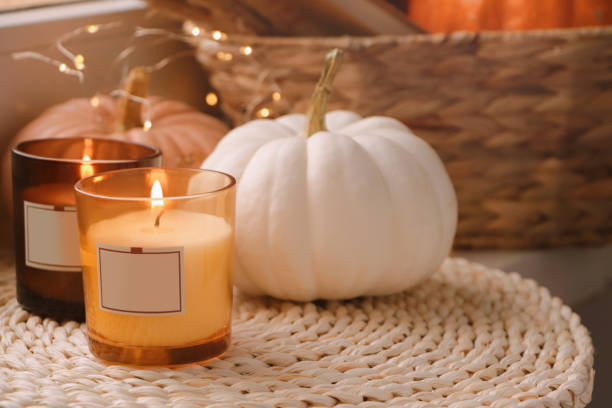 istock Scented candles and pumpkins on wicker mat indoors 1485868627