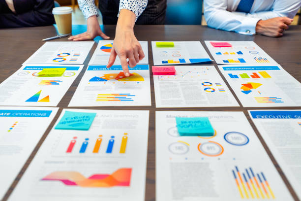 istock Paperwork and hands on a board room table at a business presentation or seminar. 1485869225