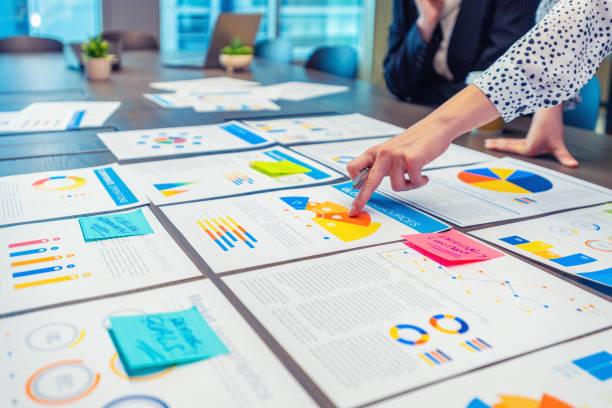 istock Paperwork and hands on a board room table at a business presentation or seminar. 1485869286