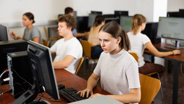 istock Focused young woman sitting at table in computer room in library 1485869668