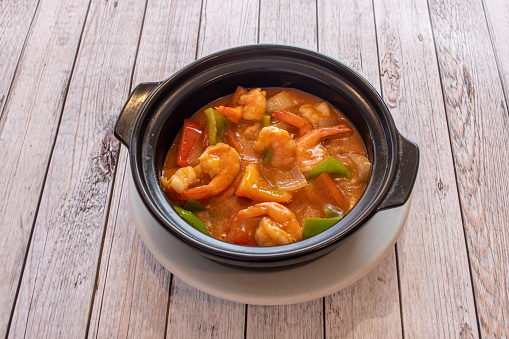 Thai prawn curry stew with chunks of red and green peppers and chunks of stewed onion.