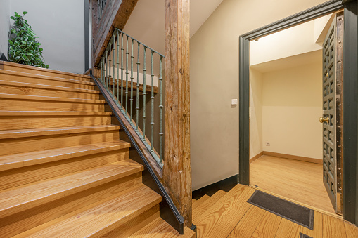 Overhead view of wooden stairs in a modern apartment. The walls are white and the stairs are made from oakwood.
