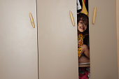 Little girl playing in the wardrobe