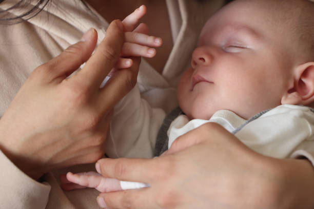 istock Newborn boy sleeping on his mother's lap 1485884608