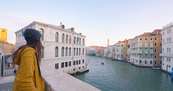Tourist woman enjoying view of Venice canal on bridge,Italy at morning.Enjoying Life Moments.