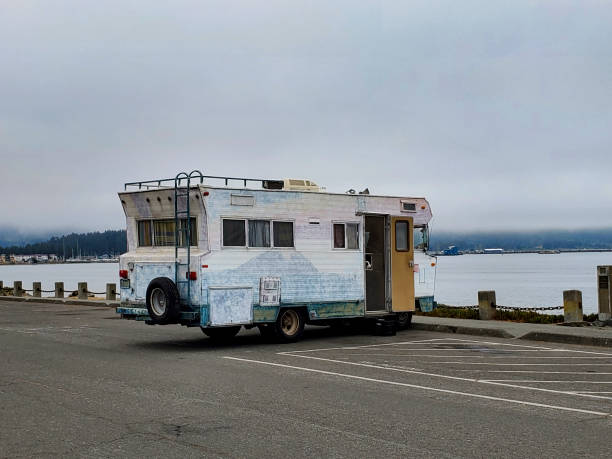 This is a photograph is of a vintage RV camper parked at the beach by the Pacific Ocean on an overcast day during the summer of 2020 in Crescent City, California.