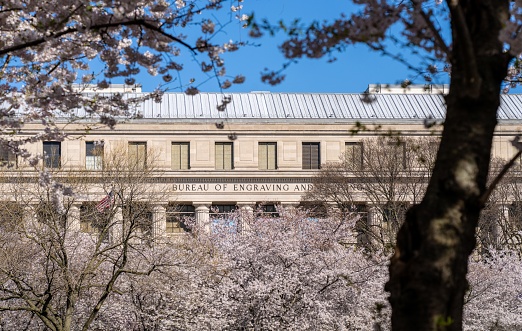 Washington D.C. - March 26 2023: The Bureau of Engraving and Printing Seen Through Cherry Blossom Trees in Washington D.C.