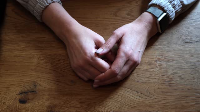 Beautiful female hands lie on the table and gesturing while talking close-up