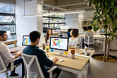 Group of business people hot desking at a coworking office