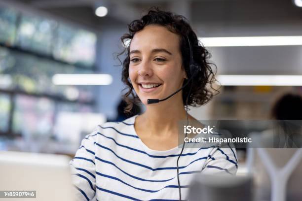 Customer Service Representative Using A Headset While Working At A Call Center Stock Photo - Download Image Now