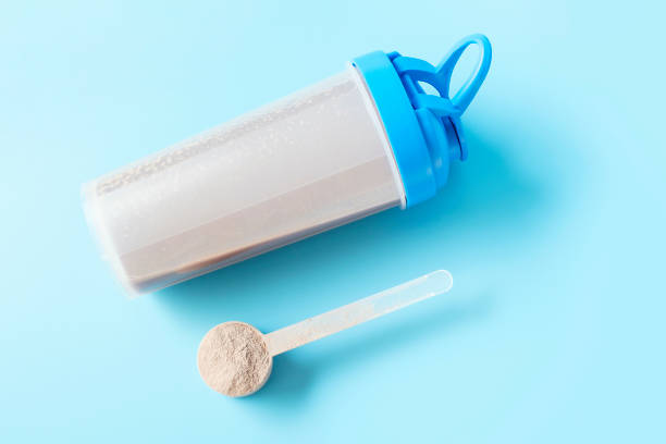 istock Shaker and scoop with chocolate protein on blue background, top view. 1485914793