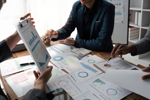 istock Business team presents and explains and using tablet discuss marketing numerical charts that display financial budgets, investments, project plans 1485925784