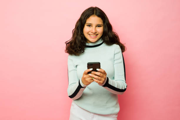 istock Cheerful hispanic teen girl using her smartphone texting 1485931258