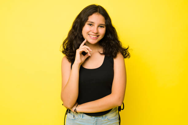 istock Beautiful thirteen year old girl posing in a yellow studio 1485933503