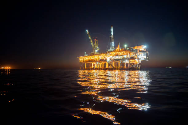 at night, the esther platform off the coast of los angeles glows with activity as a fracking drill rig extracts oil from the pacific ocean depths - oil industry industry new mexico oil drill imagens e fotografias de stock