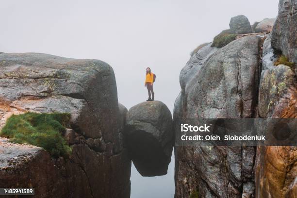 Woman Standing On Kjeragbolten Stock Photo - Download Image Now - Cliff, At The Edge Of, Bizarre