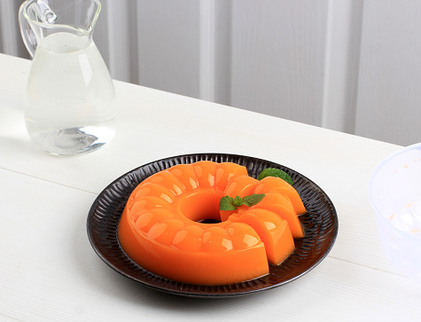 Mango Orange Pudding on Black plate with Mint Leaf