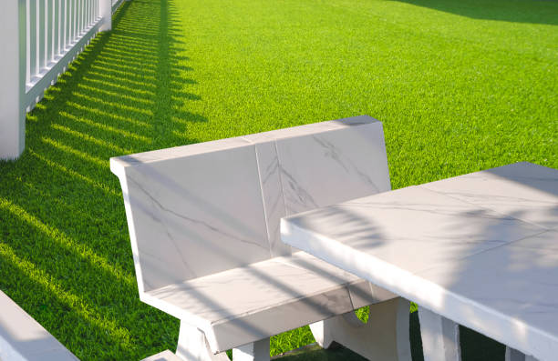 White Outdoor marble Table Set on Green Artificial Turf and white Wooden Picket in Front Yard area White Outdoor marble Table Set on Green Artificial Turf and white Wooden Picket in Front Yard area at Home stone bench top view stock pictures, royalty-free photos & images