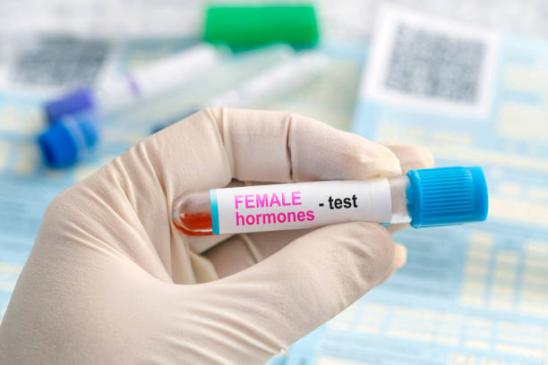 muestra de sangre para la prueba de hormona femenina sobre un fondo azul de laboratorio. - follicle stimulating hormone fotografías e imágenes de stock