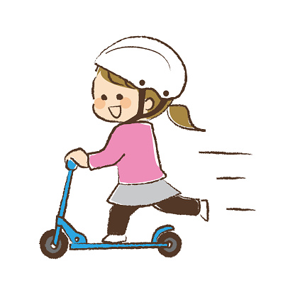 A girl wearing a helmet and riding a kickboard.