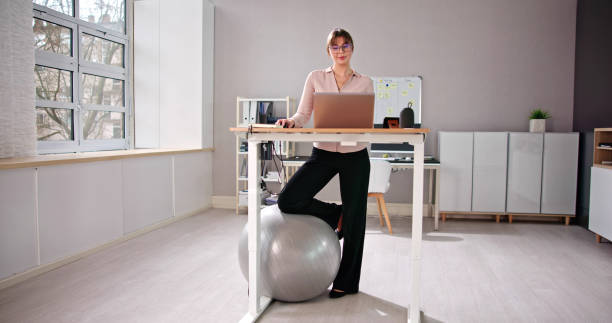 istock Woman Using Adjustable Height Standing Desk In Office 1485961853