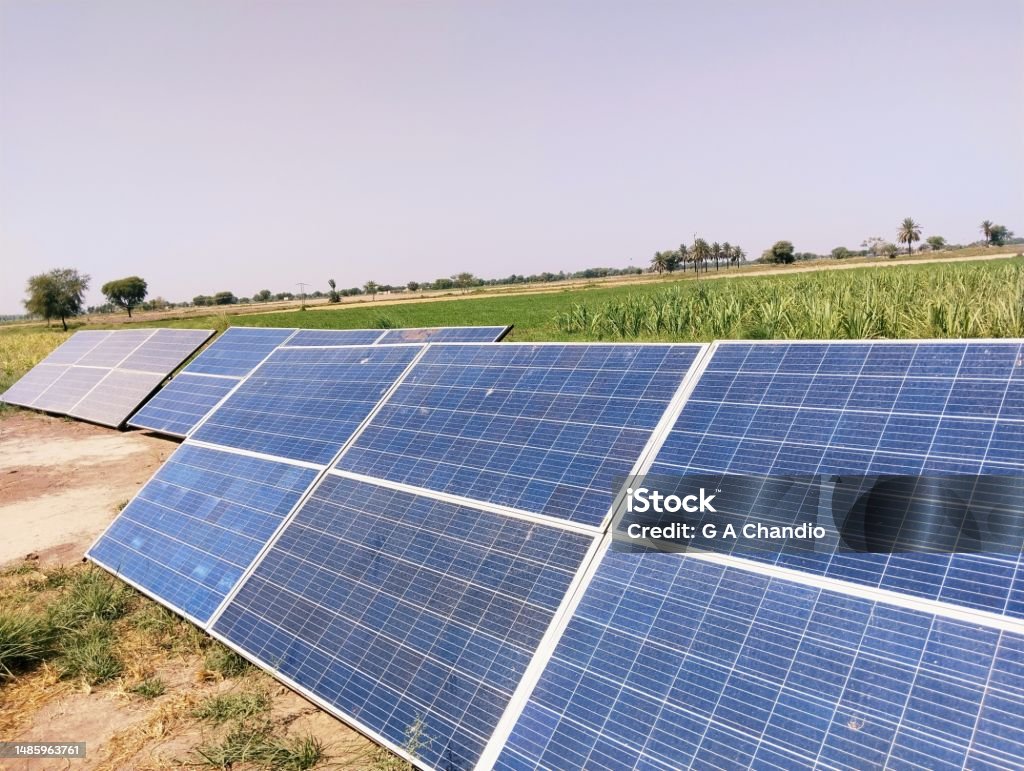 Solar panels installed in agriculture field under sunlight for irrigation tube well on solarenergy paneles solares, panneaux solaires, paineis solares, view image picture stock photo Solar panels installed in agriculture field under sun for irrigation tube well on solarenergy paneles solares, panneaux solaires, paineis solares, view image picture stock photo. Color Image Stock Photo