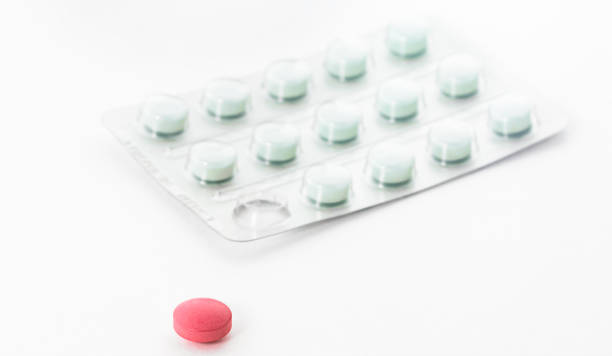 istock Mint-colored pill box with one squeezed-out red pill in the foreground. 1485963960
