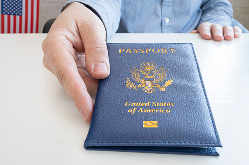 a man's hand gives an American passport. Migration Service, document verification.