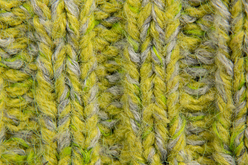 light green background of knitted fabric sweaters closeup