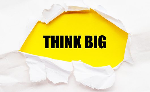 THINK BIG words on a yellow sheet of paper.