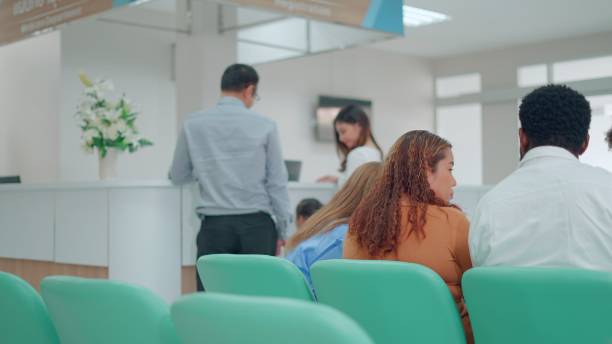 istock Hospital reception lobby with diverse patients to attend checkup visit, using appointment report to help people with disease. Waiting room area for healthcare consultation and examination  in hospital or medical clinic. 1485972218