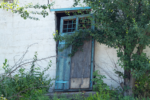 hacked old wooden door in an abandoned house in a village
