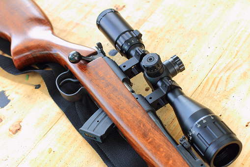 close up of rifle telescope for sport hunting on table wooden