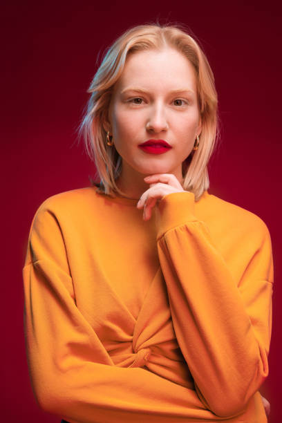istock Studio shot of a serious blond woman posing on red background. 1485983363