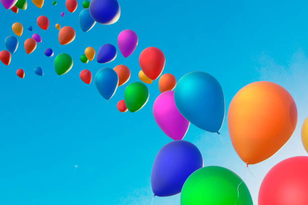 Bunch of colorful balloons floating in the sky. The balloons are of different colors and sizes, creating a vibrant and lively atmosphere. The blue sky serves as a beautiful backdrop