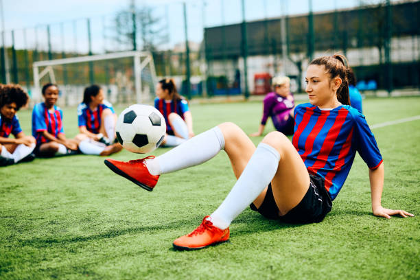 istock Female player practicing with soccer ball while warming up on playing field. 1485983474