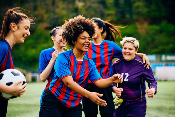 istock Cheerful black soccer player and her teammates on playing field. 1485983680