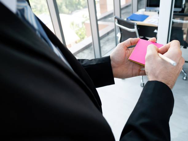 istock Caucasian manager man writing ideas on sticky note pink color close up hand use pencil with office background 1485984745