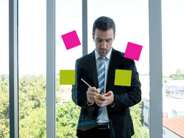 Free Stock Photo of Man writing on a sticky note surrounded by office ...