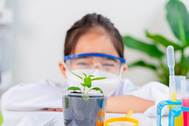 happy Asia little girl with flasks for chemistry science isolated on a white background