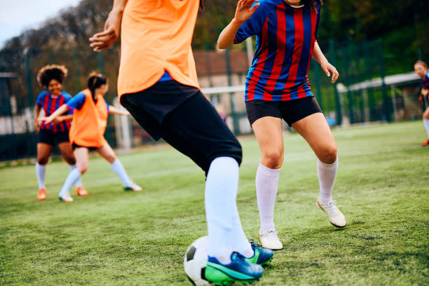 istock Unrecognizable athletic women practicing soccer on playing field. 1485986954