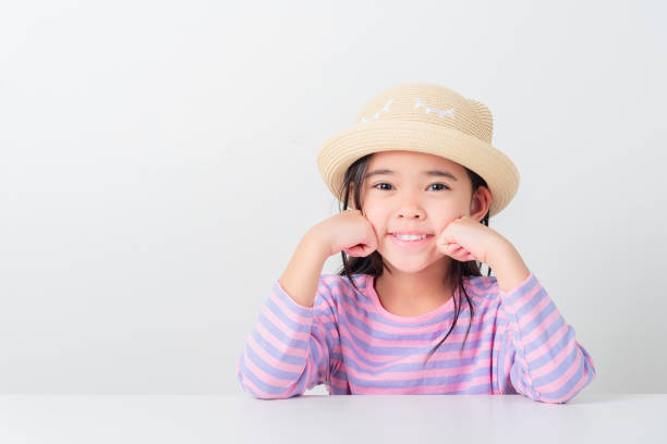 A portrait of a beautiful little girl in warm clothes against a bokeh background.