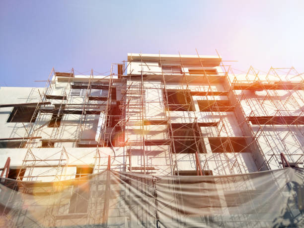 istock construction site with crane and scaffolding on blue sky background,High rise building viewed from bottom to top,perspective of the building 1485988878